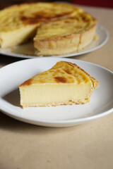A warm, appetizing slice of French custard tart (flan patisserie) on a white plate with copy space—perfect for bakery, dessert menus, blogs, and recipe features.