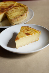 A warm, appetizing slice of French custard tart (flan patisserie) on a white plate with copy space—perfect for bakery, dessert menus, blogs, and recipe features.