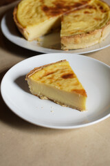 A warm, appetizing slice of French custard tart (flan patisserie) on a white plate with copy space—perfect for bakery, dessert menus, blogs, and recipe features.