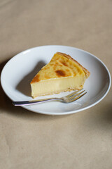 Close-up of a creamy French custard tart (flan pâtissier) slice on a white plate with a fork and generous copy space. Warm natural styling ideal for bakery menus, recipe blogs, and food editorial