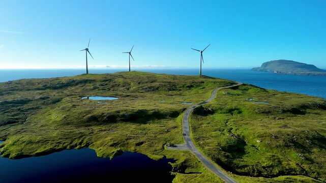 Discover the stunning beauty of the Faroe Islands, where rolling green hills meet the sea. Wind turbines stand tall against a clear blue sky, showcasing ambitious renewable energy efforts.