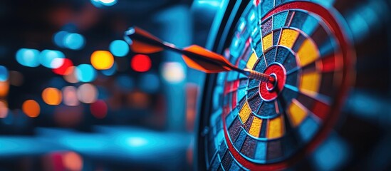 Dart hitting bullseye on a colorful dartboard with blurred bokeh background