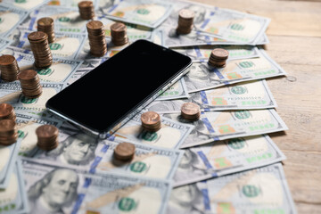 Smartphone and money on wooden table, closeup