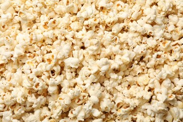 Fresh tasty popcorn as background, closeup view