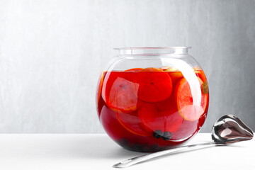 Tasty fruity punch on white table, space for text. Refreshing drink