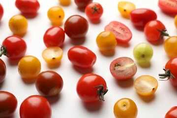 Different ripe tomatoes on white table, closeup