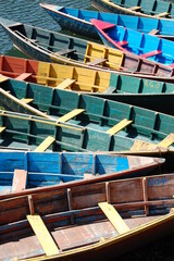 Colorful Wooden Rowboats on Phewa Lake in Bright Sunlight 