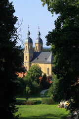 Blick durch Bäume auf die Basilika in Gößweinstein in Bayern