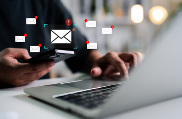 A Businessman working on a laptop, mobile phone open an email caution warning sign for notification error and maintenance concept, network security, computer virus detected, personal data protection.