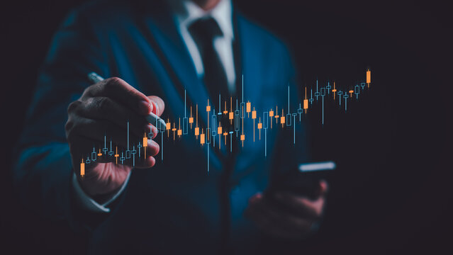 A Businessman analyzing graph financial data stock market. Business financial stock market concept. Business finance stock bar chart Hologram. Business success and growth, economic growth graph. - Powered by Adobe