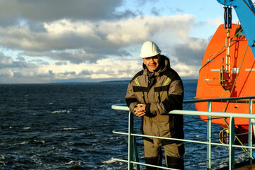 A Professional Worker on a Ship Deck, Overlooking the Vast Ocean Horizon in the Distance