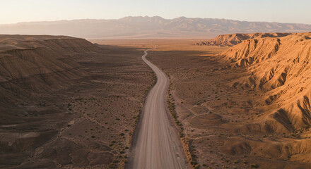 Expansive desert highway winds through dramatic canyon landscapes under warm golden hour sunlight
