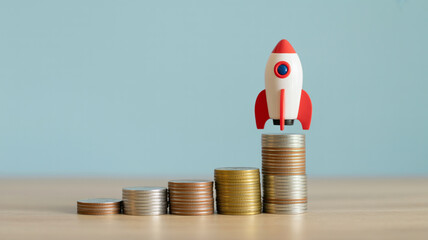 Investment growth concept with rocket on money coins stack for financial success and business startup