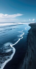 Ocean waves on a black sand beach.  Vast blue water meets a dark shore.  Fluffy white waves