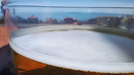 Beautiful sunny summer horizontal macro photo of glass of cold beer foam with sea view wallpaper hd high quality tranquility picture perfect for campaigns selective focus
