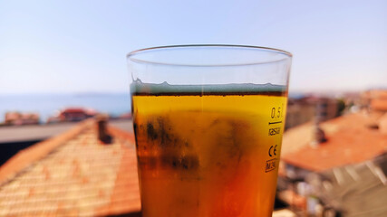 Beautiful sunny summer horizontal photo of glass of cold beer with foam with sea view wallpaper hd high quality tranquility picture perfect for campaigns selective focus