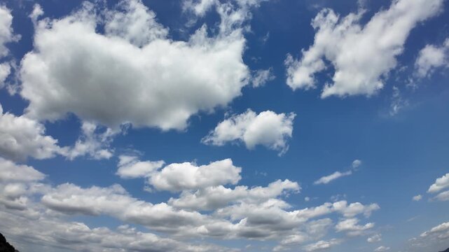 Dramatic clouds drift across a clear blue sky. Perfect for nature, landscape, and atmospheric projects.