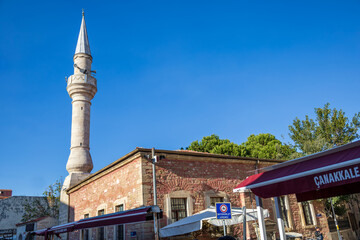 Historic Yali Mosque with stone walls and tall minaret in Çanakkale, Turkey. 