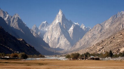 Majestic Snow-capped Mountain Range in Clear Blue Sky with Rocky Valley and Sparse Vegetation