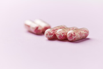 Vitamin B12 (also known as cobalamin) capsules on bright paper background. Soft focus. Close up. Copy space.	