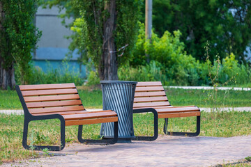 Fototapeta premium two benches for relaxing in the city park. a summer day
