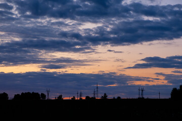 The sky is dark and cloudy with a beautiful orange sunset
