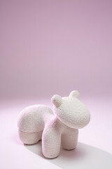 Big soft toy animal on pink background
