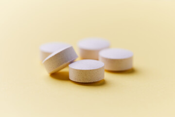 Creatine tablets on paper background. Soft focus. Close up. Copy space.	