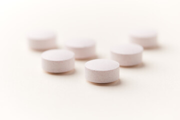 Creatine tablets on paper background. Soft focus. Close up. Copy space.	