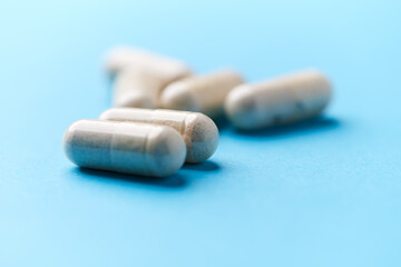 Creatine tablets on paper background. Soft focus. Close up. Copy space.	