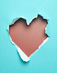 Heart-shaped hole in light blue paper