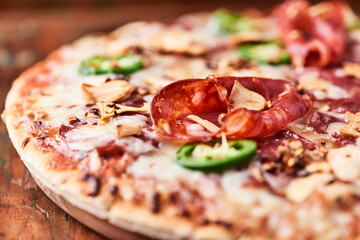 Pizza with salami, mozzarella cheese and jalapeno pepper. Wooden background. Soft focus. Copy space.	