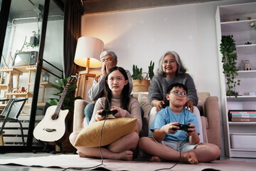 Happy family together playing games, many girls and boys holding joysticks playing games, little...
