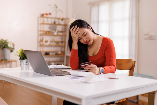 Financial owe asian woman, female sitting on floor home, stressed and confused by calculate expense from invoice or bill, have no money to pay, mortgage or loan. Debt, bankruptcy or bankrupt concept.
