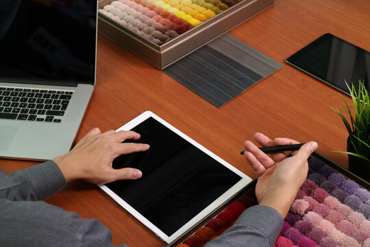 Interior designer working with tablet and fabric samples - Powered by Adobe