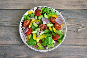 Fresh and Colorful Salad with Vegetables in a Plate on wooden table cut out