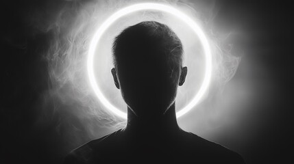 A silhouetted man with a bright glowing ring or halo behind his head
