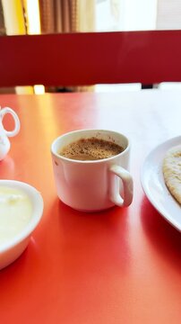 4K Vertical shot of hot tea cup with breakfast in local restaurant in Keylong, Lahaul, India. Healthy morning breakfast. Homemade Food and drink concept. Tourist experience local food while travelling
