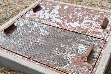 Underground electrical vault under heavy steel doors. Rusted diamond plated steel.