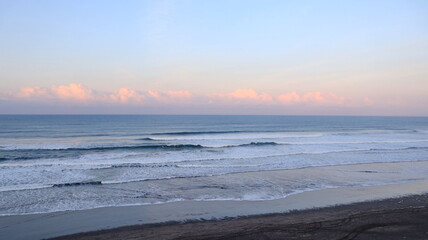 Ocean waves rolling to shore with foamy surf, tranquil seascape and blue water horizon background