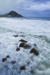 From the Sagüés viewpoint, waves crash powerfully against the coast of Donostia-San Sebastian, painting Zurriola beach with their foam, Basque Country.