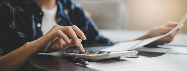 Close up hands people calculating credit card debt on the table