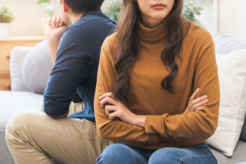 Family problem concept, Close-up hands of Asian wife sitting on sofa and husband sitting back to...