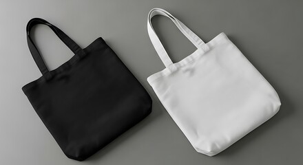 Two canvas tote bags, one black and one white, on a gray background