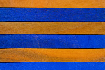 Horizontal arrangement of alternating blue and orange wooden sticks, abstract colorful craft...