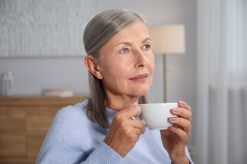 Beautiful senior woman having tea at home
