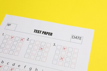 Answer sheet on yellow background, closeup. Student passing exam