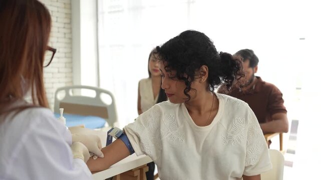 A phlebotomist performs a venipuncture on a patient to collect a blood specimen for hematology and clinical chemistry analysis in a diagnostic laboratory setting.