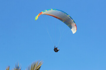 Paraglider flying in a blue sky	
