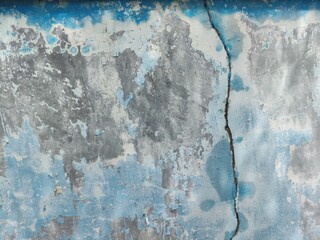 Abstract Close-up of Weathered Wall with Peeling Blue Paint and Vertical Crack